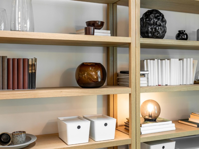 Minimal shelving with decor books and warm lamp light scandi interior